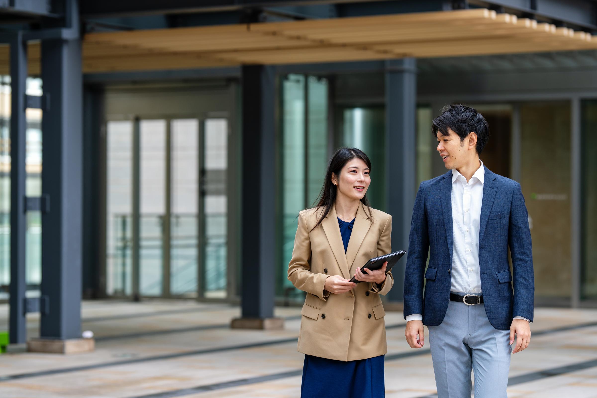 Two people walking outside of an office